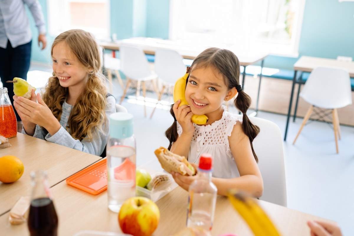Niños comiendo alimentos saludables en la escuela