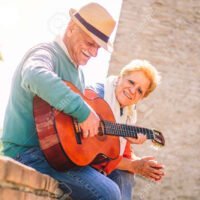 119153784-feliz-pareja-senior-tocando-una-guitarra-y-teniendo-una-cita-romantica-al-aire-libre-personas
