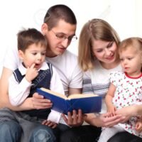 15645077-familia-feliz-leyendo-un-libro-en-el-sofa