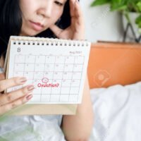 175579541-mujer-asiatica-estresada-mirando-el-calendario-que-tiene-problemas-con-el-ciclo-menstrual-esperando