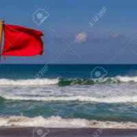 bandera-roja-ondeando-en-la-playa