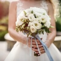 flores-ramo-novia-sosteniendo-flores-blancas-ramo-boda-cerca_359031-19175