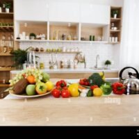 interior-de-la-cocina-frutas-y-verduras-frescas-en-la-mesa-2aymn48