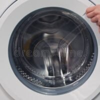 mano-intentando-abrir-tapa-de-lavadora-atascada