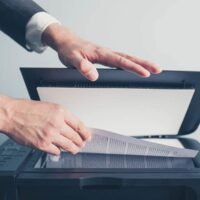manos-escaneando-documento-con-la-computadora