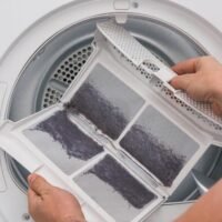 manos-limpias-limpiando-filtro-de-lavadora