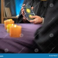 manos-sosteniendo-cartas-de-tarot-sobre-mesa