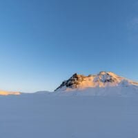 montanas-nevadas-iluminadas-sol-amanecer-islandia-todo-entorno-nevado-cielo-despejado_617744-549