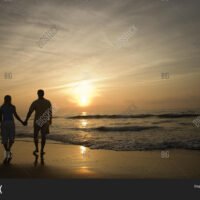 pareja-caminando-por-la-playa-al-atardecer