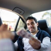 persona-pagando-en-efectivo-a-conductor-de-uber