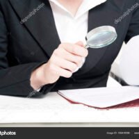 persona-revisando-documentos-financieros-con-lupa