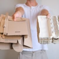 persona-sostiene-paquetes-huevos-cajas-carton-sus-manos-sobre-fondo-blanco-separa-recicla_384592-1018
